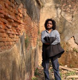 Full length of young man standing against wall