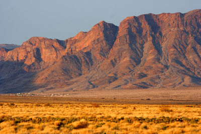 Scenic view of arid landscape and mountains against sky