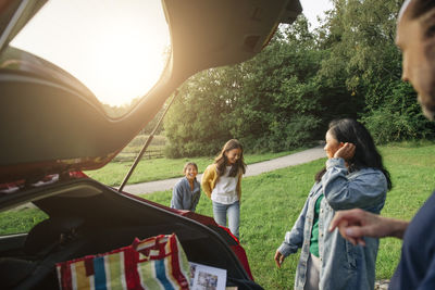 Family enjoying together during picnic near car at park