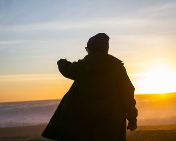 Silhouette man standing against sky during sunset