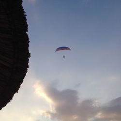 Low angle view of people paragliding