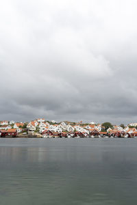 Scenic view of sea by townscape against sky