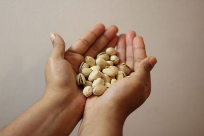 Cropped image of hand holding apple against white background