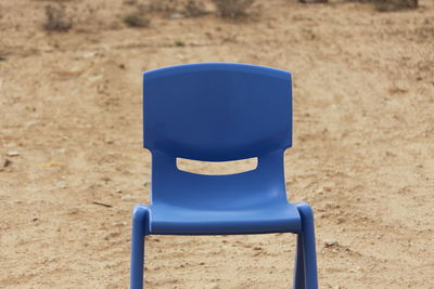 Close-up of empty chair on sand