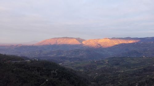 Scenic view of mountains against sky at sunset
