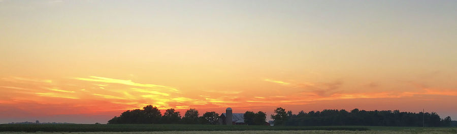 Scenic view of landscape against orange sky