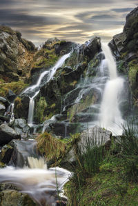 Scenic view of waterfall against sky