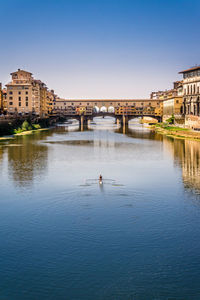 Row boat on river in front of buildings