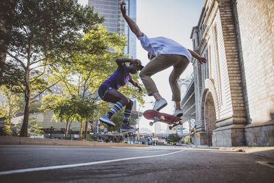 Young people jumping on skateboard in city