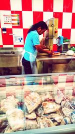 Man standing by fish for sale in market