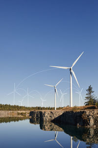 Wind turbines and blue sky reflecting in water