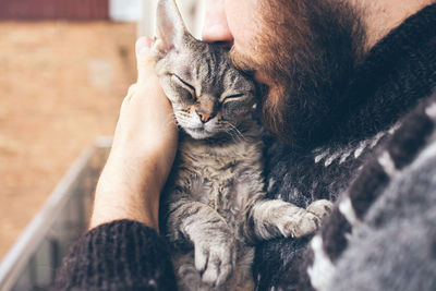 Midsection of person with cat relaxing outdoors