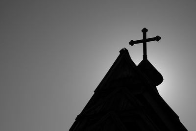 Low angle view of weather vane against clear sky