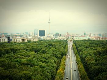 High angle view of road passing through national park with cityscape in background