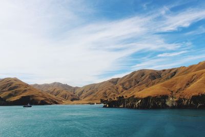 Scenic view of sea and mountains against sky