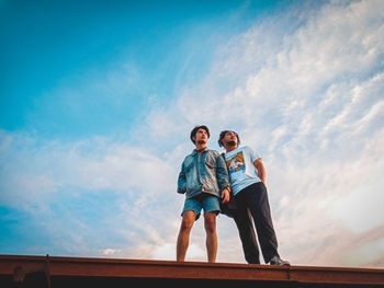 Low angle view of a man jumping against sky