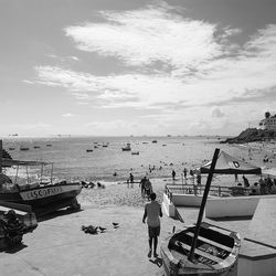 People at beach against sky