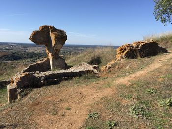 Rock formations on field against clear sky