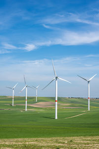 Wind turbines and green agricultural landscape seen in puglia, italy