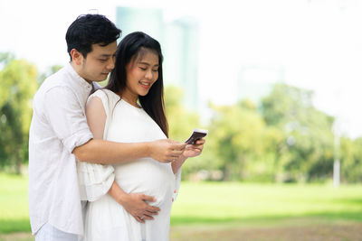 Young couple holding smart phone outdoors