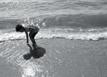 Rear view of boy in water at beach