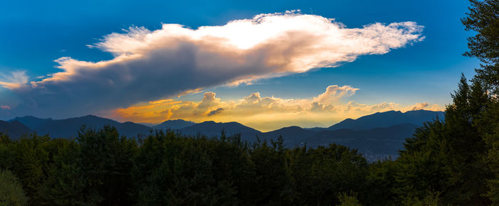 Panoramic view of trees and mountains against sky