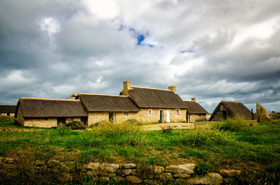 Old house on field against sky