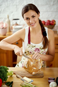 Portrait of woman preparing food on kitchen island at home