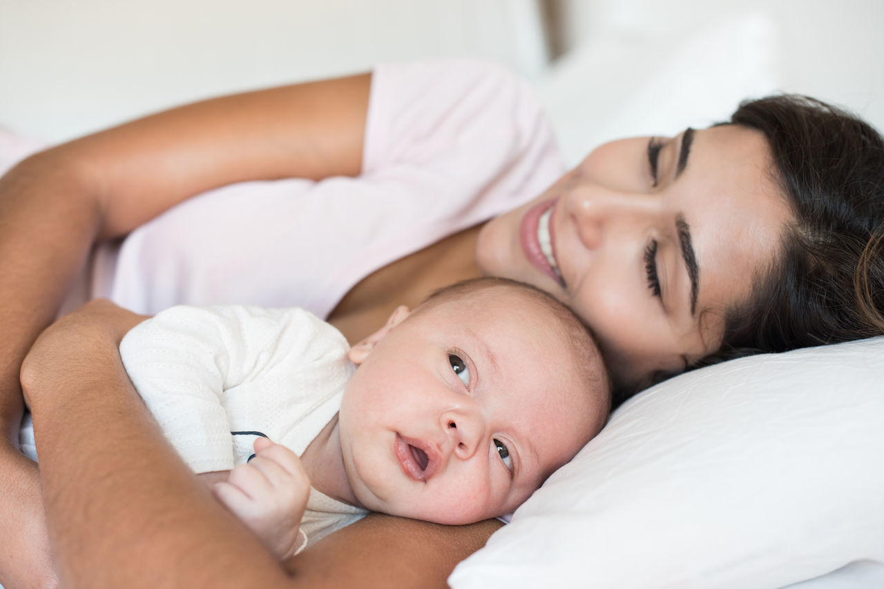 PORTRAIT OF BABY GIRL LYING IN BED