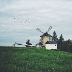 Wind turbines on field against sky