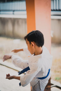 Boy standing in front of built structure