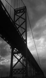 Low angle view of bridge against cloudy sky