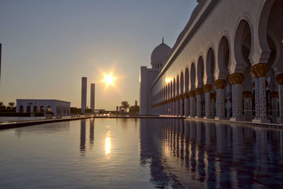 Reflection of buildings in city at sunset