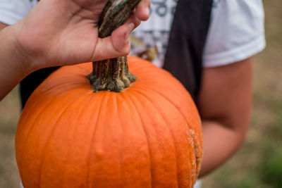 Close-up of hand holding pumpkin during autumn
