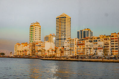 River by buildings against sky in city