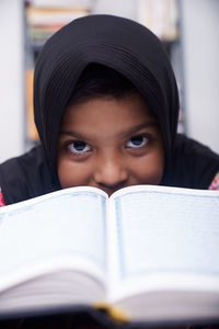 Cute muslim little girl reading koran