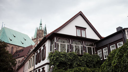 Low angle view of trees and buildings against sky