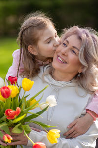 Portrait of smiling young woman holding flowers