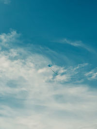 Low angle view of airplane flying against sky