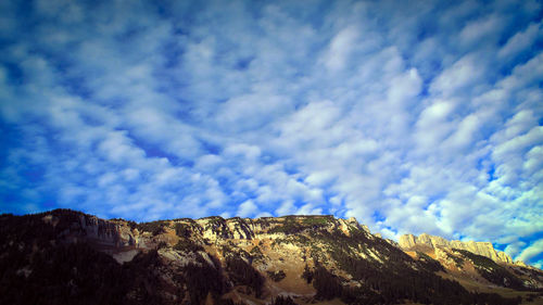 Low angle view of mountain against blue sky