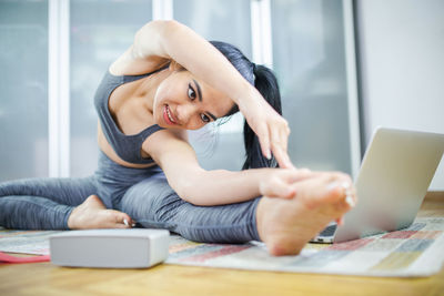 Young woman using mobile phone in laptop