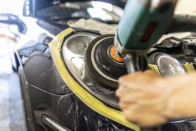 Cropped hand of man repairing car