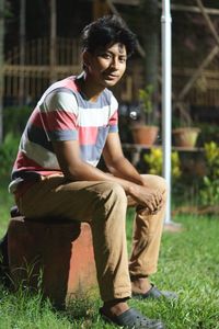 Portrait of young man sitting on grass