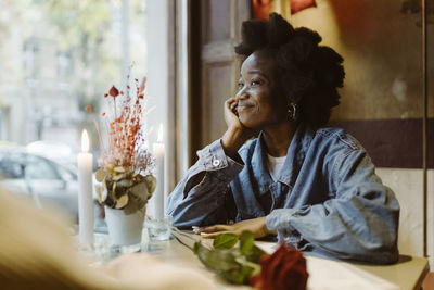 Smiling romantic woman staring at boyfriend during date at bar