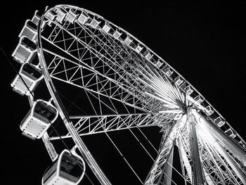 Low angle view of illuminated ferris wheel against sky at night