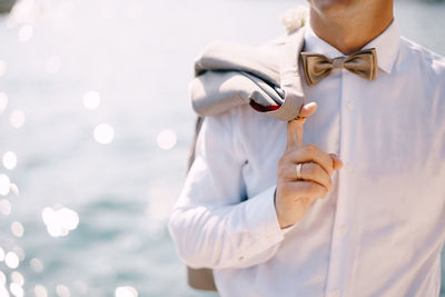 Midsection of man holding white umbrella