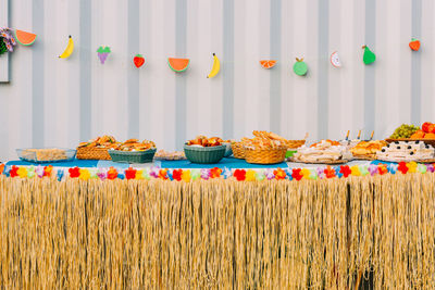 Side view of assortment of finger party food on a table with decorations