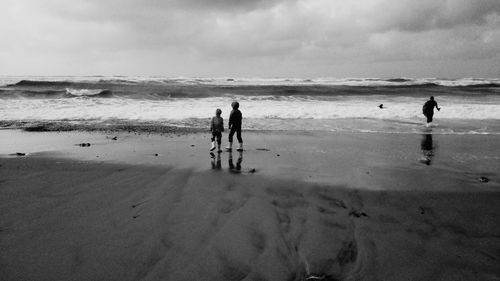 People on beach against sky