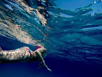 Woman wearing bikini swimming in sea