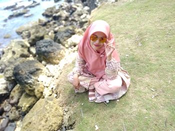 High angle view of girl sitting on rock